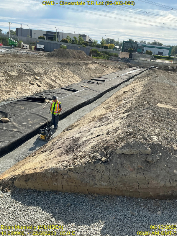 Side backfilling and vibratory plate compaction along wrapped tank
